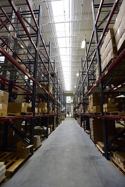 Inside the warehouse, tall shelving lines left and right walls